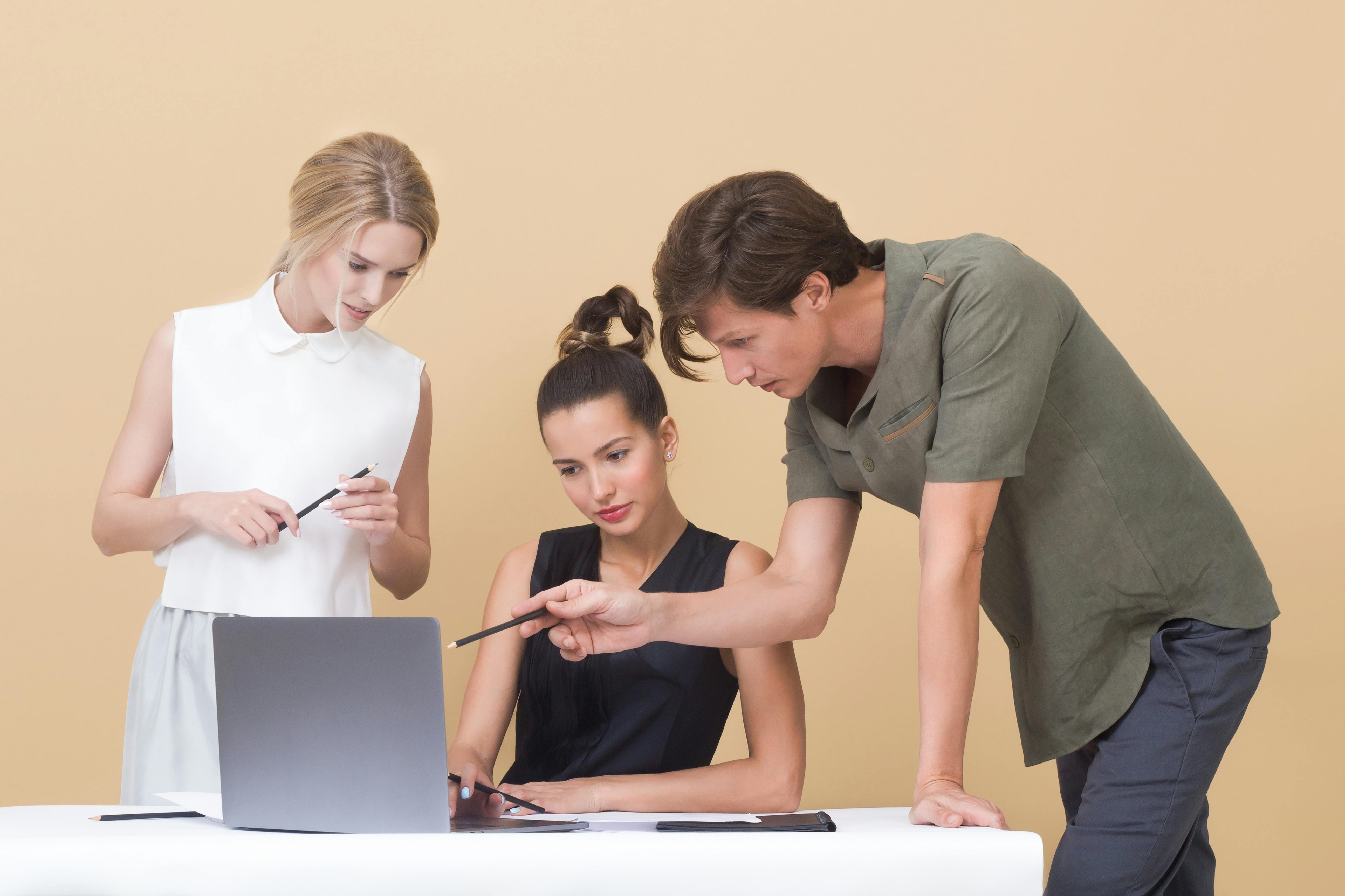 People working around a laptop